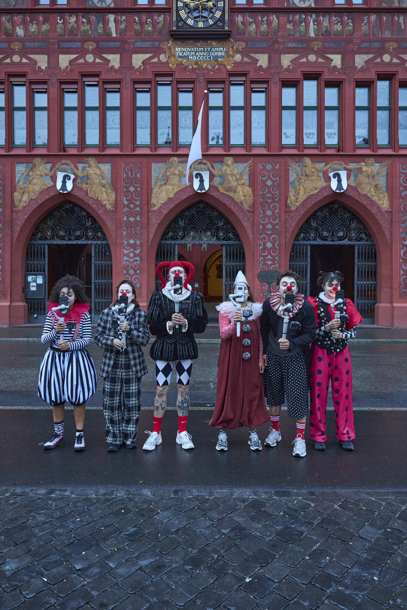 Sechs Clowns in der Stadt Basel mit Selfiekameras, die sie vor sich halten