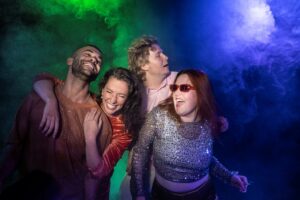 vier Personen feiernd auf einem Bild in grünblauem Nebel