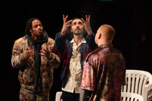 Drei Personen auf einem Bild, die in der Mitte hat die Hände und den Blick erhoben